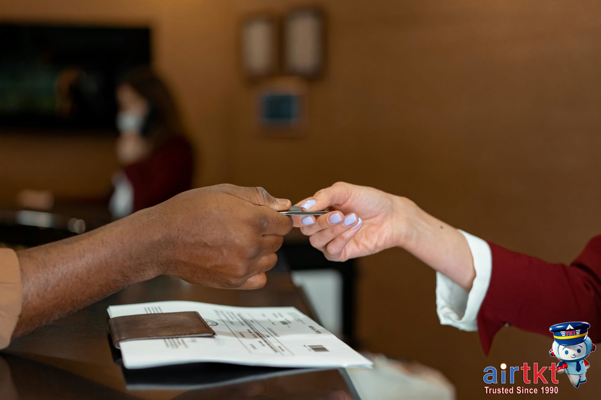 Traveler using credit card at hotel reception desk