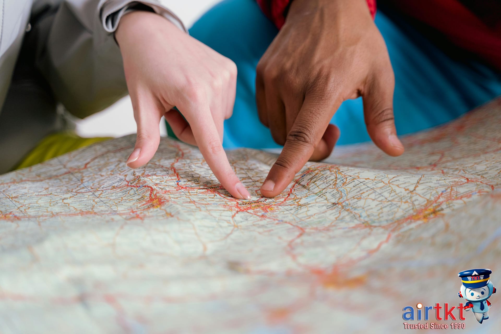 Hands pointing at a detailed travel map for itinerary planning