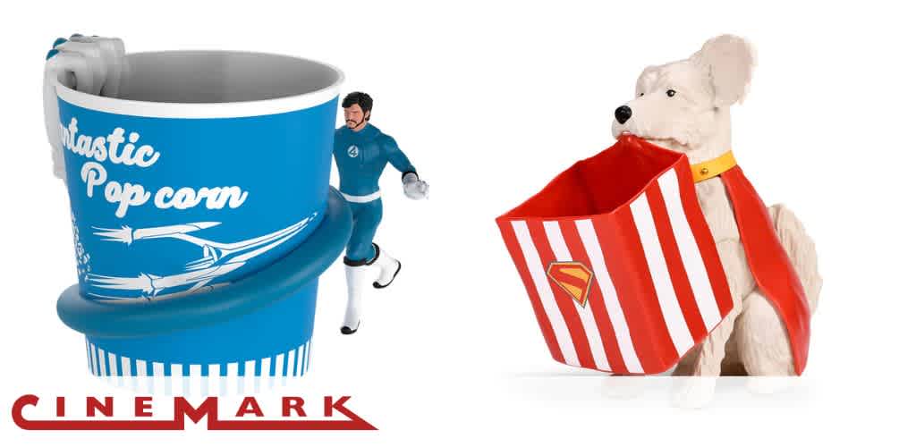 Two promotional popcorn buckets: one blue with superhero theme and one shaped like a dog with a red cape and popcorn holder.