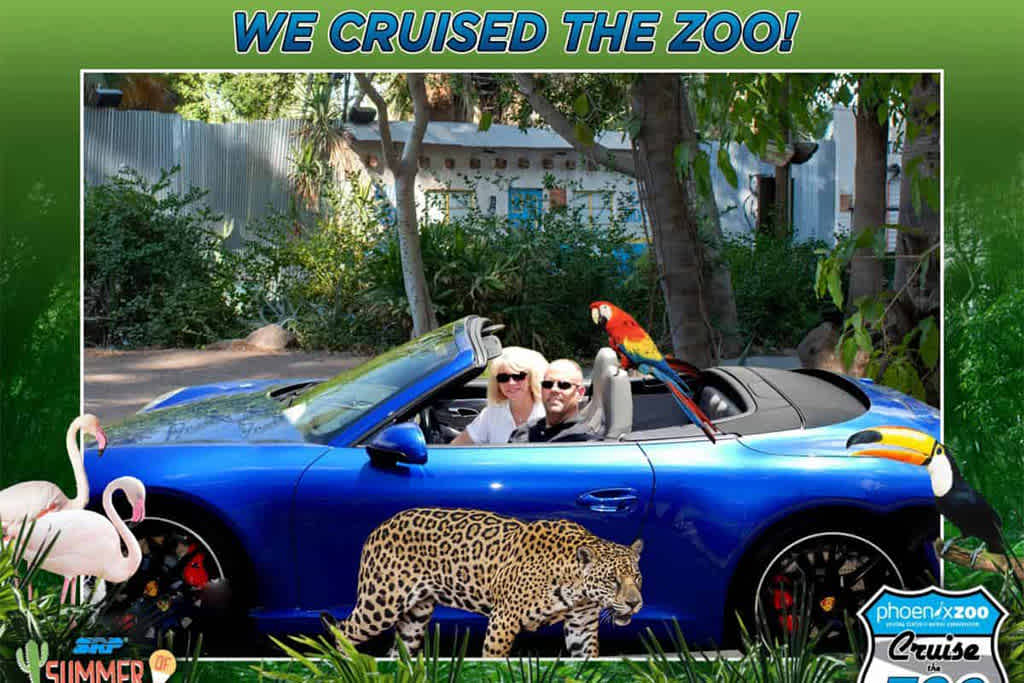 Two people in a blue convertible surrounded by zoo-themed graphics.