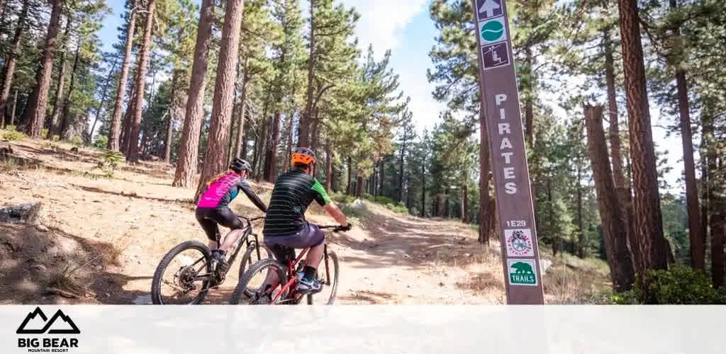 Image description for FunEx.com:

The image features a scenic outdoor setting at the Big Bear Mountain Resort, where two mountain bikers are enjoying a ride on a dirt trail. The cyclists, one wearing a bright orange helmet and the other in a pink top, are viewed from the side as they pedal their way through a tranquil forest populated with tall pine trees and a clear sky above. A signpost on the right-hand side of the trail indicates the path's name, "Pirates", with a green circle denoting the difficulty level as easy, so it's suitable for riders of all skill levels. The trail number is "129". In the distance, the dense woodland creates a serene backdrop for the adventure ahead.

Don't miss out on the excitement of trail riding at the Big Bear Mountain Resort — visit FunEx.com to grab your tickets at the lowest prices, ensuring you get the best savings on your next outdoor adventure!