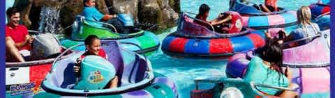 People in colorful bumper boats enjoying a sunny day on the water.