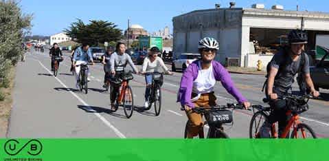 Group of cyclists riding on a sunny day with clear skies.