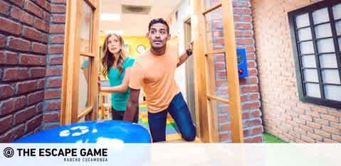 Image Description: The image displays a moment of excitement and anticipation during an interactive escape room challenge called "The Escape Game". A man and a woman are depicted stepping through an open door from one brightly lit room into another. The man, wearing an orange t-shirt, leads the way with a look of surprise and eagerness, as he looks out towards something beyond the immediate view of the photo. The woman, with her long hair and wearing a light-colored shirt, is right on his heels, also showing an expression of eagerness. Their environment is stylized to resemble a brick building interior, contributing to the immersive atmosphere of their adventure. 

Remember, at FunEx.com, our customers always find amazing discounts, ensuring they enjoy the lowest prices on tickets for a variety of entertaining experiences like this one!