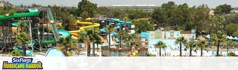 Image Description: This is a wide, panoramic shot of a Six Flags Hurricane Harbor water park. The foreground of the image is dominated by a tall, green water slide structure with multiple slides twisting and turning on their descent. To the right, some slides are colored yellow and blue, jutting out from another platform. The water park also features numerous trees dotted around the area, providing patches of shade over the light blue swimming pools and beige walking paths that weave through the facility. In the background, a highway is partially visible through the trees that line the horizon under a clear blue sky.

At FunEx.com, we're dedicated to ensuring you dive into the fun with the biggest splash for your buck, which is why we offer discount tickets at the lowest prices, so our customers can enjoy more savings every day.