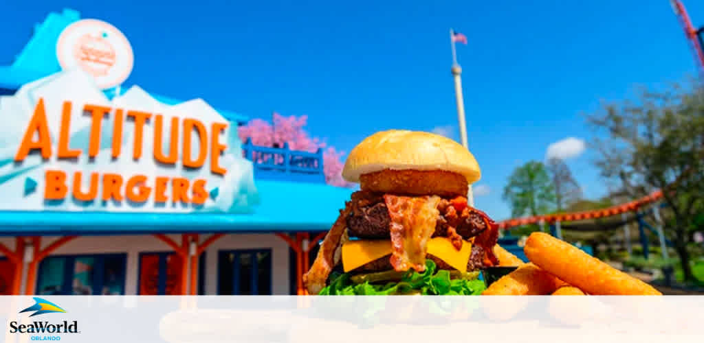 In the image, a juicy burger takes center stage, garnished with lettuce and cheese, accompanied by crispy fries. In the background, the vibrant blue and orange sign of Altitude Burgers can be seen under a clear sky, with a blurred amusement park ride and trees surrounding the area, hinting at a fun and delicious dining experience at SeaWorld Orlando.