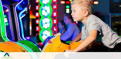 Child riding amusement ride at a vibrant indoor arcade.