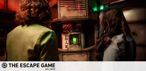 Two individuals in a dimly lit escape room facing puzzle controls. © The Escape Game Orlando.