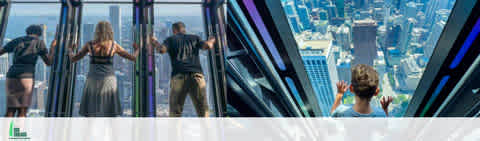 Visitors experience a city skyline from a high vantage point with floor-to-ceiling windows. Four individuals appear exploring the view: One presses their hands against the glass, two stand by the railing gazing out, and another sits with their back to the camera, looking downward.