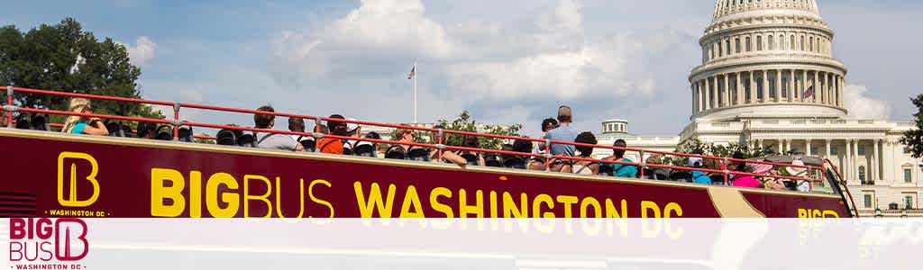 A red double-decker tour bus labeled 'BIG BUS WASHINGTON DC' is parked with passengers seated on the upper deck. In the background, the United States Capitol dome is visible under a clear sky.