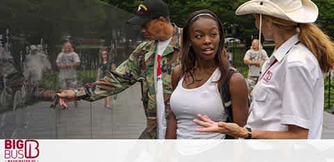 Image displays three people interacting on a city street. To the left, a person wearing a camouflage jacket gestures outward. Centrally, a young woman looks surprised, facing the right. Another individual wearing a white shirt with a 'Big Bus Tours' logo engages with the young woman. A faded city scene and the 'Big Bus' logo overlay the bottom.