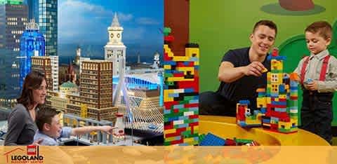 A family is engaging in a playful activity at a Legoland Discovery Center. There is a detailed Lego cityscape in the background. In the foreground, an adult and two children are building with Lego bricks on a yellow surface, smiling and enjoying their time together. The Legoland logo is visible at the bottom.