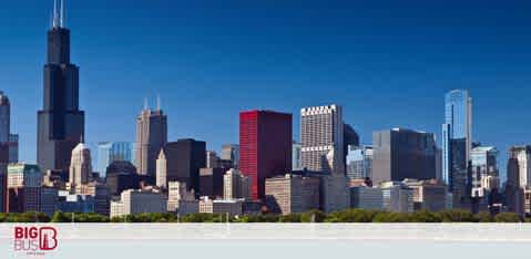 The image presents a clear day view of a city skyline with various skyscrapers dominating the scene. The tallest building stands out prominently against a bright blue sky. In the foreground, calm water reflects bits of the architecture. There's a logo in the bottom left corner with the text 'BIG BUS'.