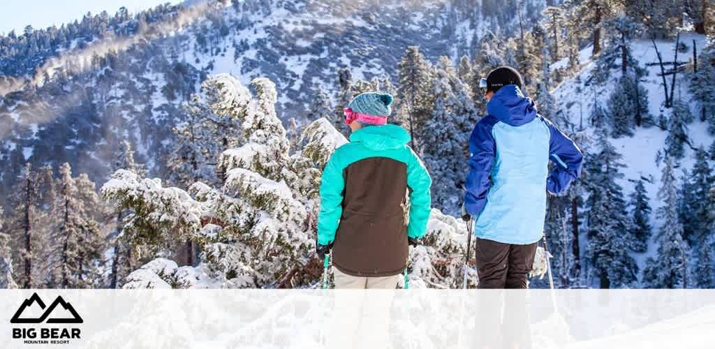 This image features two individuals standing at the edge of a snow-covered landscape, possibly at the top of a slope or hill, with their backs to the camera. The person on the left appears to wear a teal, black, and white ski jacket, paired with a pink beanie, while the person on the right sports a blue and black ski jacket with a dark hat. They are both looking out towards a picturesque scene dominated by snow-laden pine trees and a backdrop of mountain peaks under a clear blue sky. The logo of "Big Bear Mountain Resort" is visible in the bottom left part of the image, suggesting that this location could be Big Bear Lake in California. An expanse of untouched white snow spans the foreground, enhancing the serene, wintry atmosphere of the scene.

For those looking to embrace the chill of winter with a frosty adventure, remember that FunEx.com is your go-to source for the lowest prices, offering great discounts and savings on tickets to breathtaking destinations like this one.