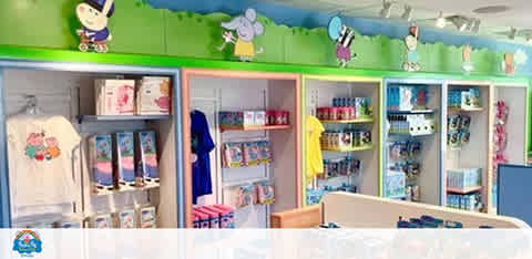 Colorful children's store with toys, clothes, and decor on shelves and wall illustrations above.