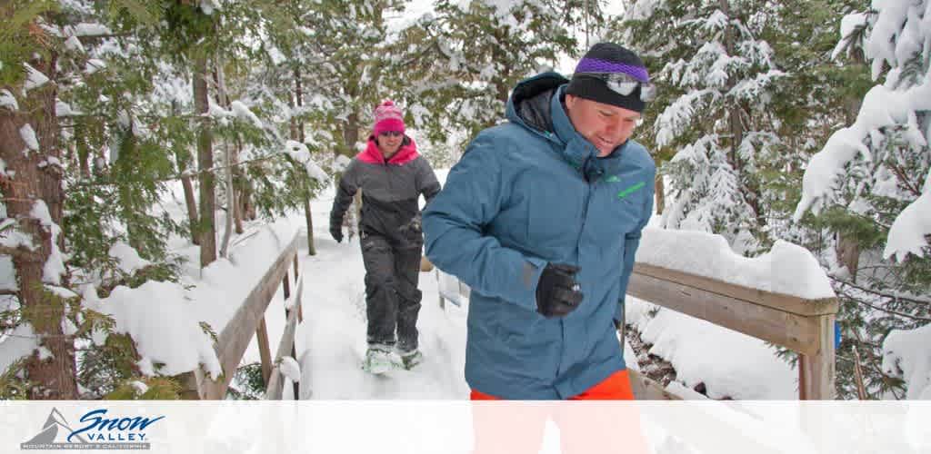 Image Description: This is a dynamic outdoor winter scene. Two individuals are engaged in snowshoeing along a narrow, wooden bridge nestled among thickly snow-covered trees. The foreground features a man dressed in a blue jacket and black gloves, focused on his steps, with snowshoes on his feet. Trailing behind is a woman wearing a bright pink hooded jacket and black pants, also wearing snowshoes. Both are actively participating in this winter activity, surrounded by a serene, natural landscape blanketed in snow. The image also displays the "Snow Valley" logo in the lower left corner, suggesting a resort or park setting.

Plan your winter adventure with FunEx.com, where you can always count on finding the lowest prices on tickets, ensuring your savings are as monumental as your experiences!