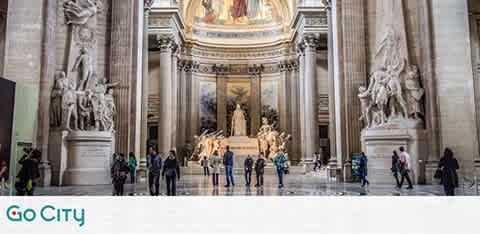 Image of a spacious neoclassical hall with visitors. Central marble sculpture surrounded by grand columns, intricate reliefs, and a large painting under a vaulted ceiling. The Go City logo is at the image's lower right corner.