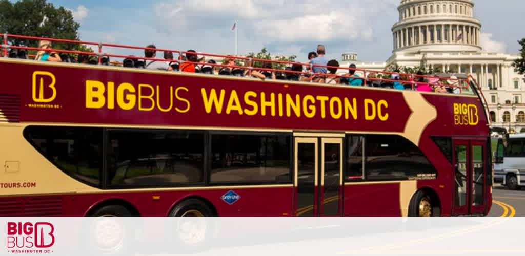 A red double-decker Big Bus with 'Big Bus Washington DC' written on the side is driving on a sunny day. In the background, the Capitol Building is visible. There are passengers sitting on the upper open deck enjoying a tour.