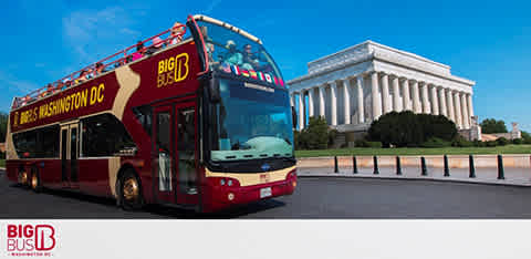 Image shows a red double-decker tour bus with 'BIG BUS WASHINGTON DC' printed on the side stopped on a road. The background features the Lincoln Memorial under a clear blue sky. The bus has an open top deck with a few passengers seated, ready for a tour.