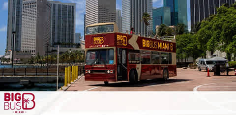 A Big Bus Miami tour bus with an open top in a sunny cityscape.