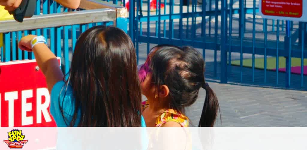 Child presenting ticket at amusement park entrance.