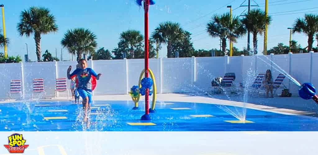 Child plays in a water park with colorful equipment under a sunny sky.