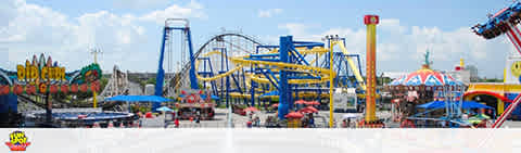 Panoramic view of an amusement park with roller coasters and rides.