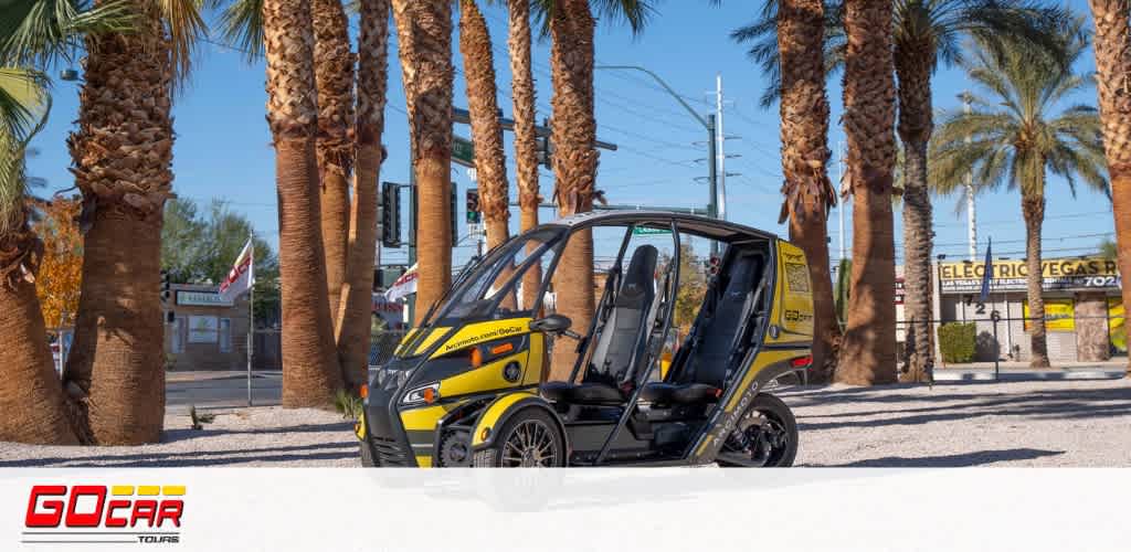 Image Description: This is a bright, clear image showcasing a small, yellow and black three-wheeled GoCar parked on a smooth, light-toned surface. Behind the vehicle, there's a row of tall palm trees with thick, textured trunks lined up under a clear blue sky. In the background, a smattering of elements such as flags, a streetlamp, and signage are visible, with one sign reading "ELECTRIC" in large letters. The GoCar logo is prominent in the foreground, suggesting this is a tour service offering. The scene suggests a warm, sunny setting, likely in a tourist-friendly area.

At FunEx.com, you can find the lowest prices on tickets and enjoy additional savings on a variety of attractions, ensuring your adventure is both memorable and affordable.