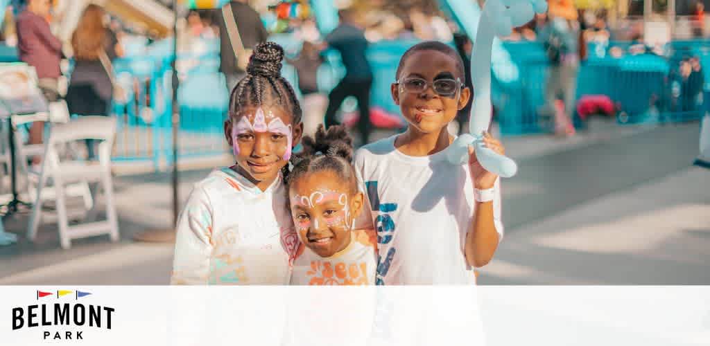 This image displays three joyful children at Belmont Park, with a blur of amusement park activities in the background. The children are standing in the foreground, smiling towards the camera. The child on the left has intricate white face paint and is wearing a high ponytail; the child in the middle also features white face paint with a bright expression. The third child is grinning broadly and holding a blue balloon fashioned into an animal shape. The children and the festive atmosphere exude a sense of delight and youthful energy. The bright sunny day contributes to the cheerful ambiance of the scene.

Remember, at FunEx.com, your excitement is just a click away with our exclusive discounts, ensuring you always get the lowest prices on tickets to your favorite destinations.