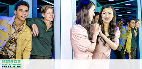 Image shows a group of people in a corridor lined with mirrors, expressing excitement and anticipation. On the left, a man and woman peek around a corner, while on the right, two women engage in a delighted conversation. The scene suggests a lively, interactive environment.