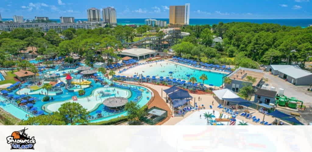 Aerial view of a vibrant waterpark near a beach with trees and high-rises in the background.