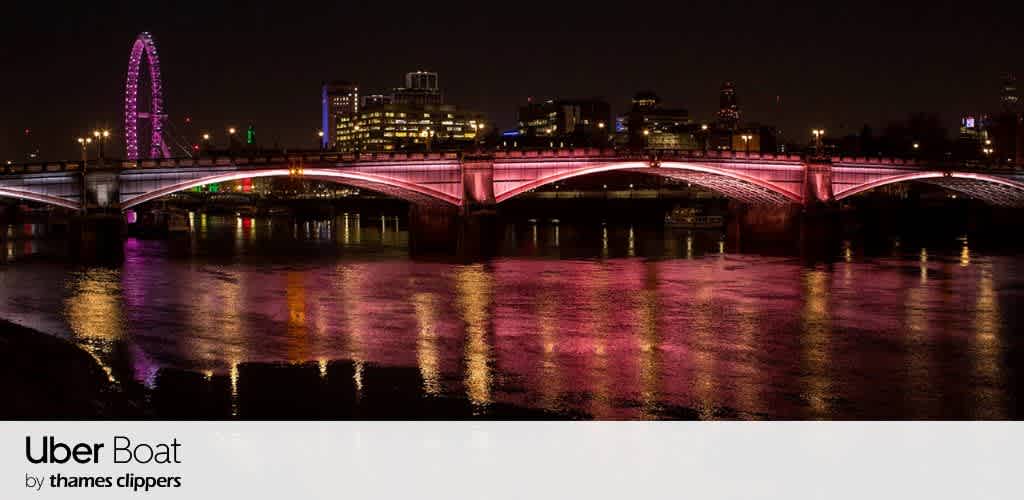 Night view of a cityscape featuring a vibrantly lit bridge over a river. The bridge displays pink lighting, reflecting on the water below. In the background, a lit-up Ferris wheel and city buildings are visible, adding to the urban night atmosphere. The scene is peaceful and colorful, encapsulating a lively city at night.