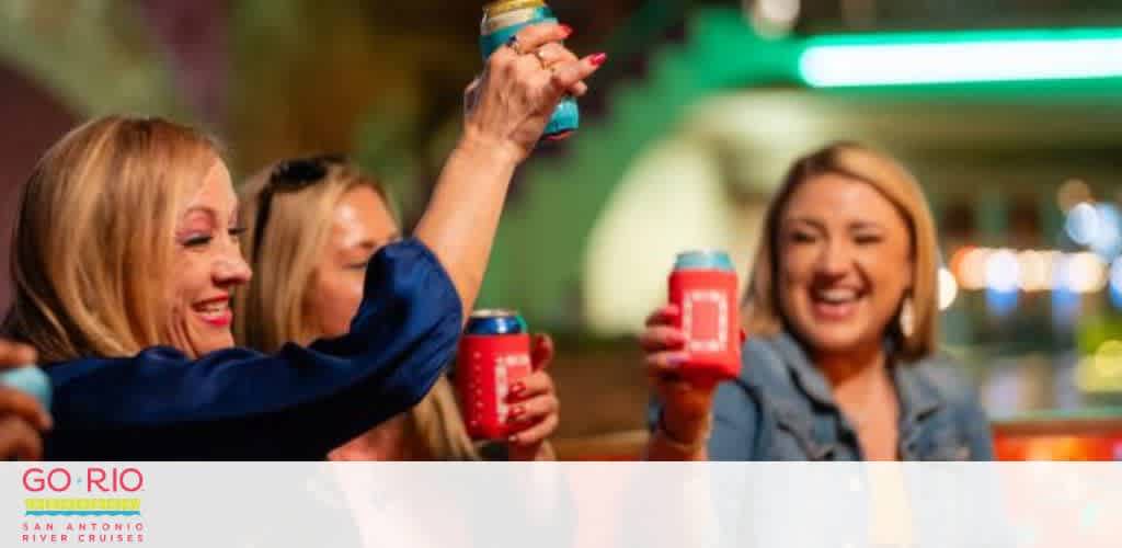 People toasting with drinks wrapped in colorful koozies at a lively gathering.