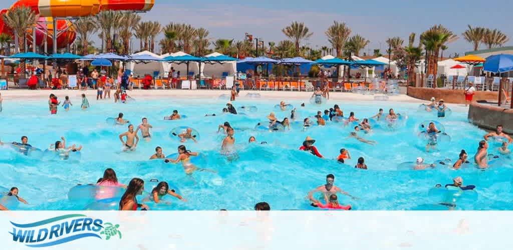 People enjoying a wave pool at a water park, with palm trees and cabanas in the background.