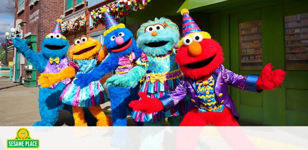 Colorful Sesame Street characters in festive outfits outside a decorated building.