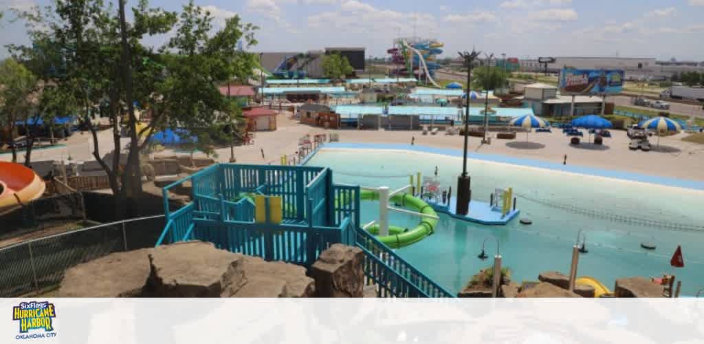 A water park with pools, slides, and shaded seating areas, viewed from above.