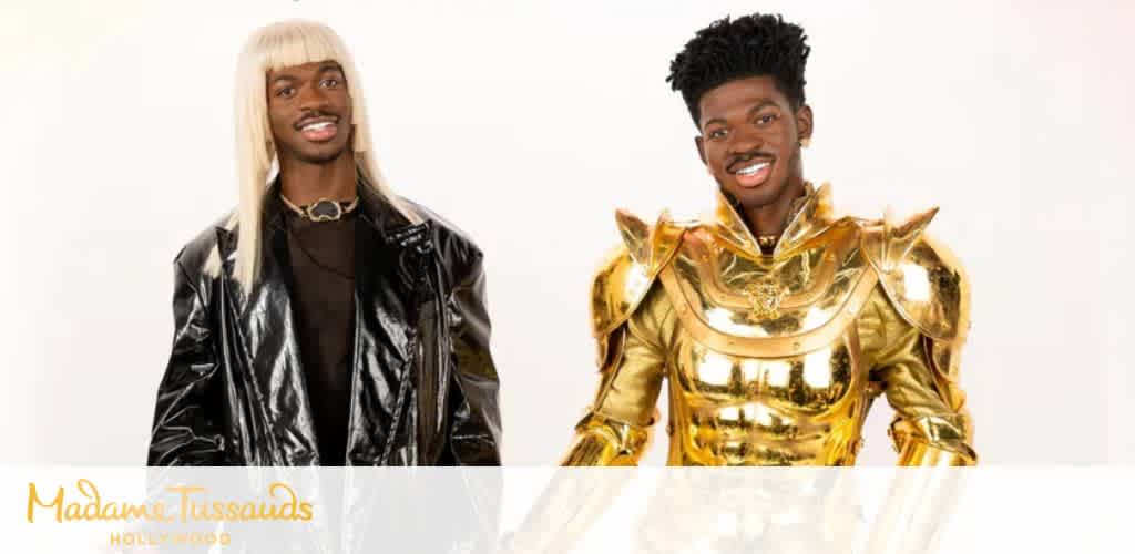 Two individuals dressed in bold, shiny outfits pose happily against a plain white background for Madame Tussauds Hollywood.