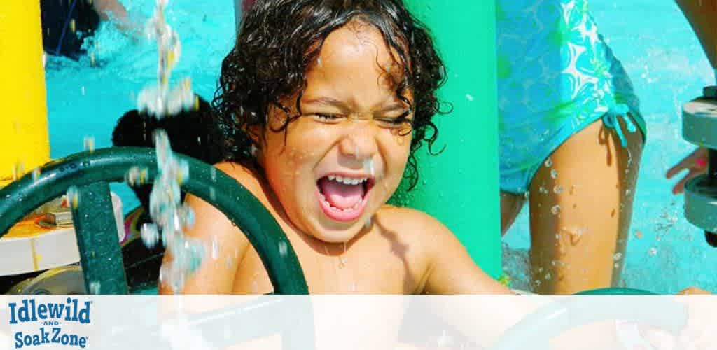 Child playing in a water park with water splashing.