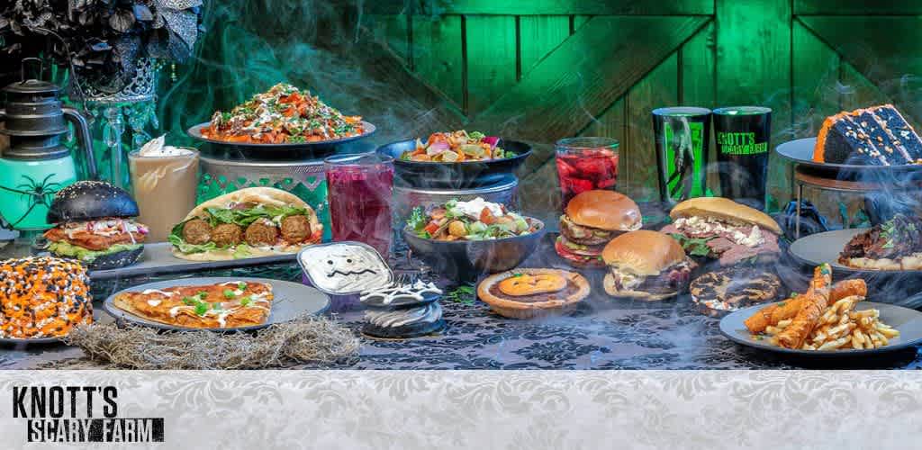 A tabletop filled with Halloween-themed food and decor against a green-lit backdrop.