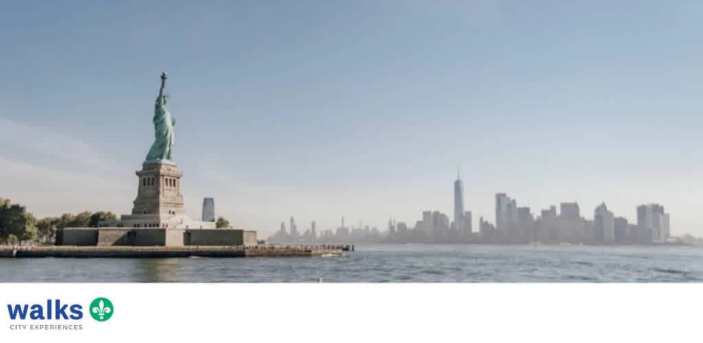 A wide view of the Statue of Liberty with New York City skyline in the background on a clear day