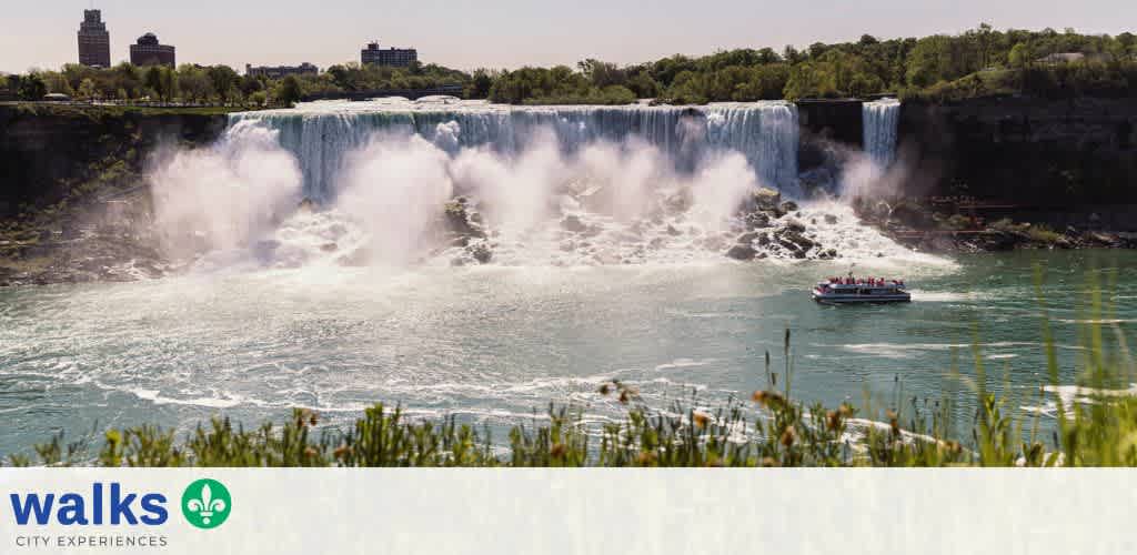 A boat tours Niagara Falls with cascading waterfalls and lush greenery in the background under clear skies
