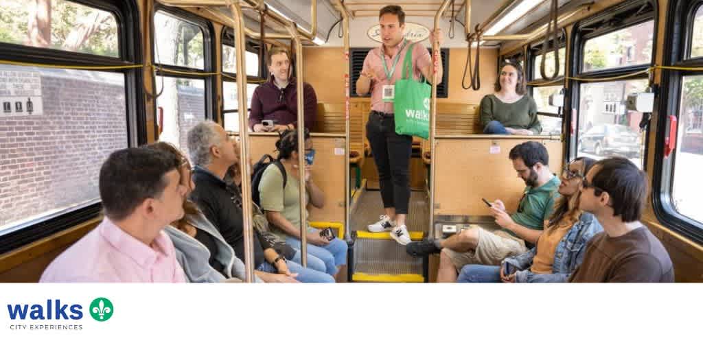 Group of diverse people riding a city bus with some seated and some standing, engaging with their phones or conversing.
