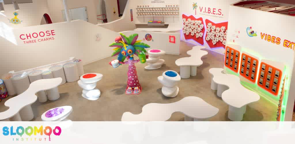 Colorful play area with seating, a whimsical tree sculpture, and vibrant walls featuring educational and sensory displays for children