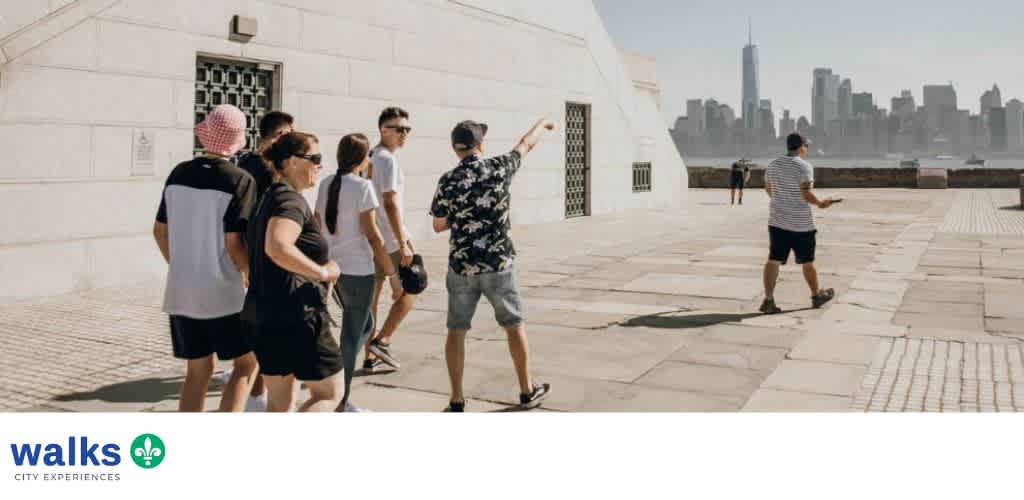 Group of people walking and sightseeing at an outdoor historical site with city skyline in the background