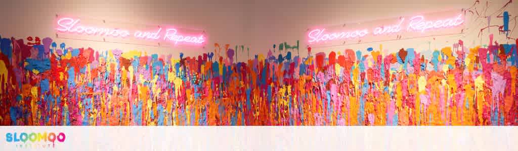 Bright, colorful abstract wall art with a neon pink sign that reads Showmo and Repeat on a white background with the company logo at the bottom left