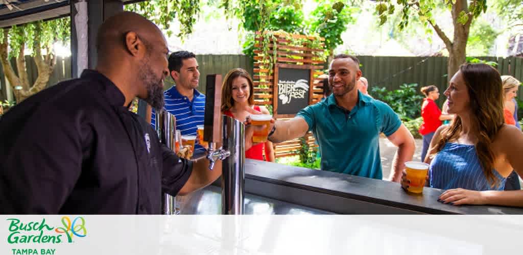 Bartender serving drinks to smiling guests at an outdoor bar.