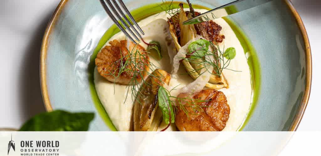 Artfully plated food dish featuring crispy items, creamy puree, and fresh herbs on a greenish ceramic plate.