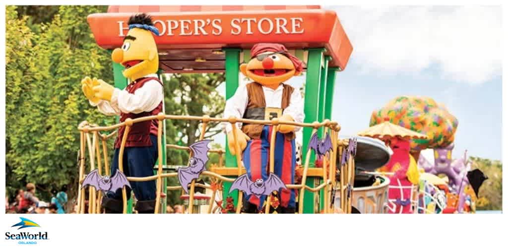Two costumed characters on a parade float in front of a sign that reads