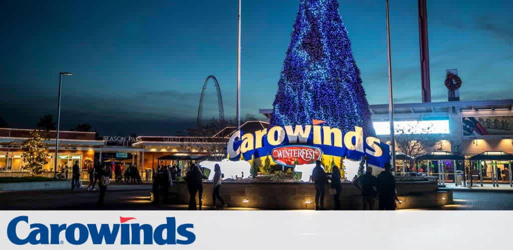 Carowinds entrance decorated for WinterFest with a large lit Christmas tree and signs.