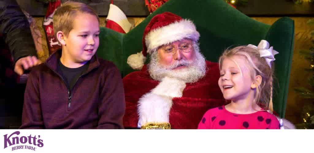 Santa Claus sitting in a green chair with a young boy and girl during a festive holiday scene.